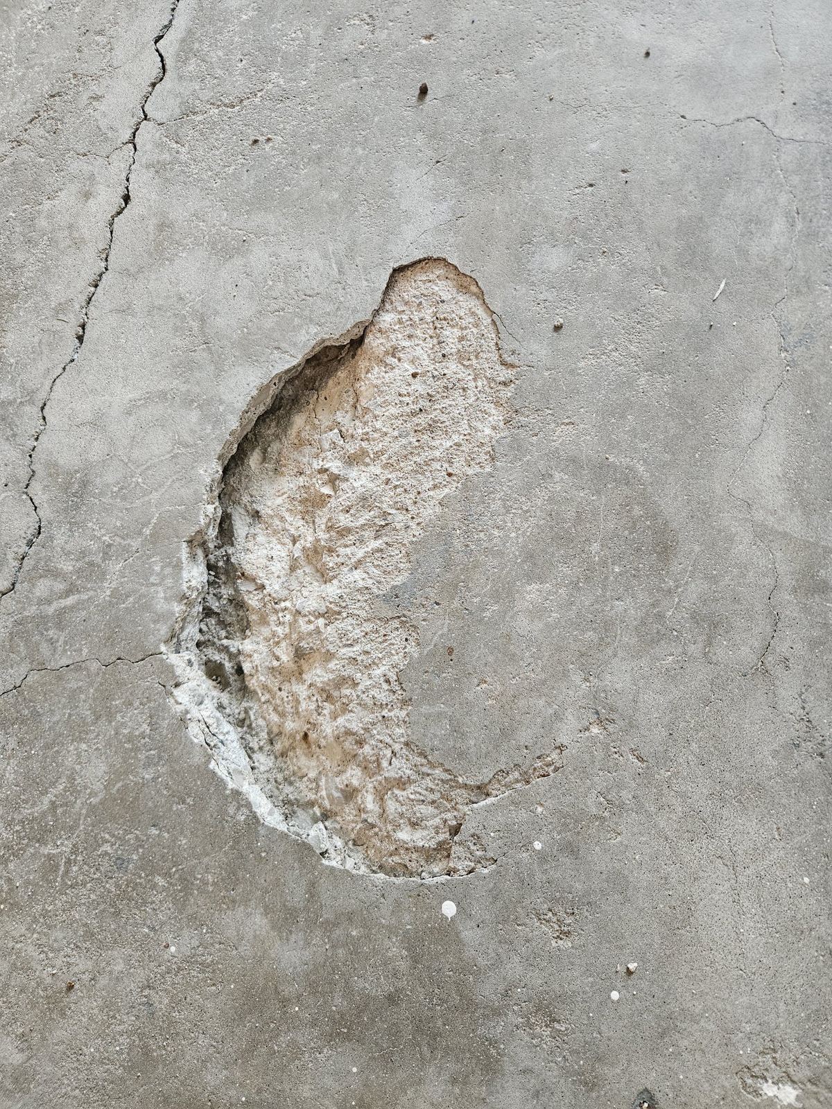 Cracked concrete with a large spall before repair.