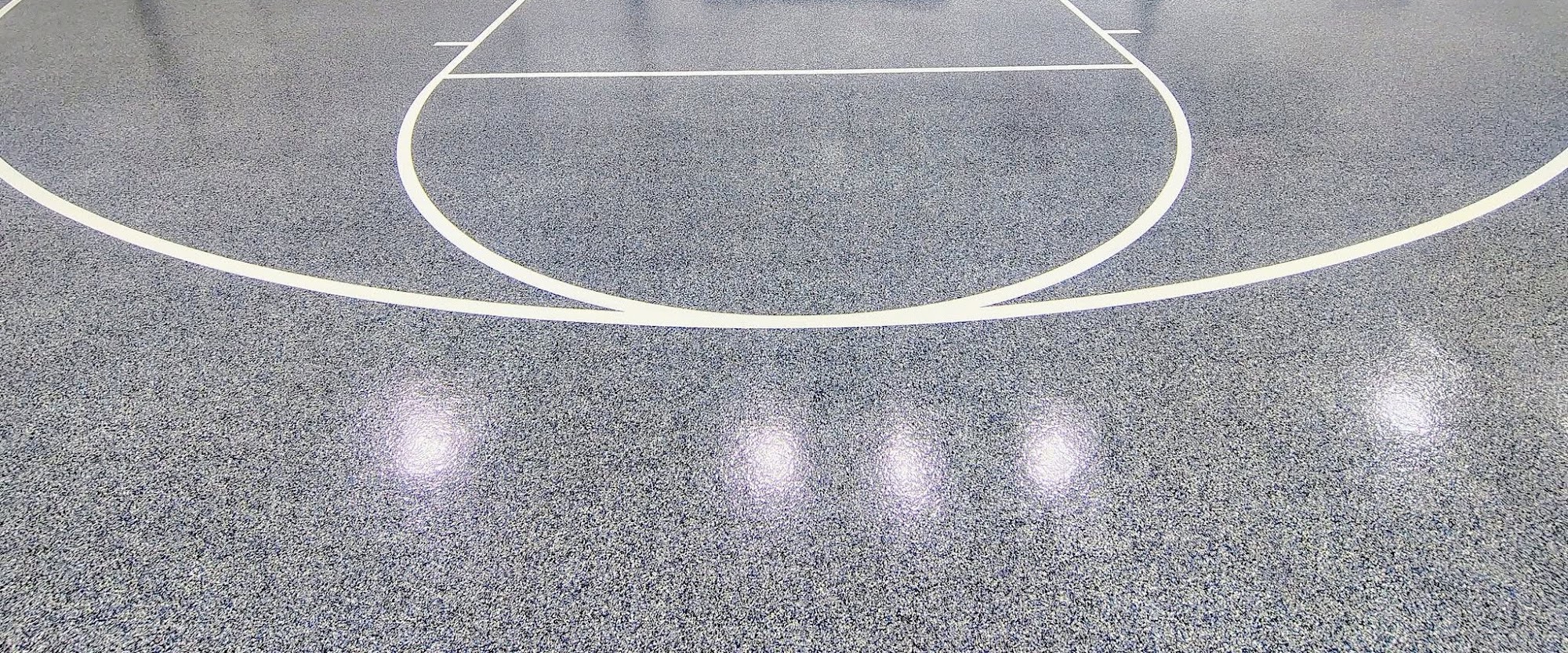 Close-up of a gray flake floor with a white line