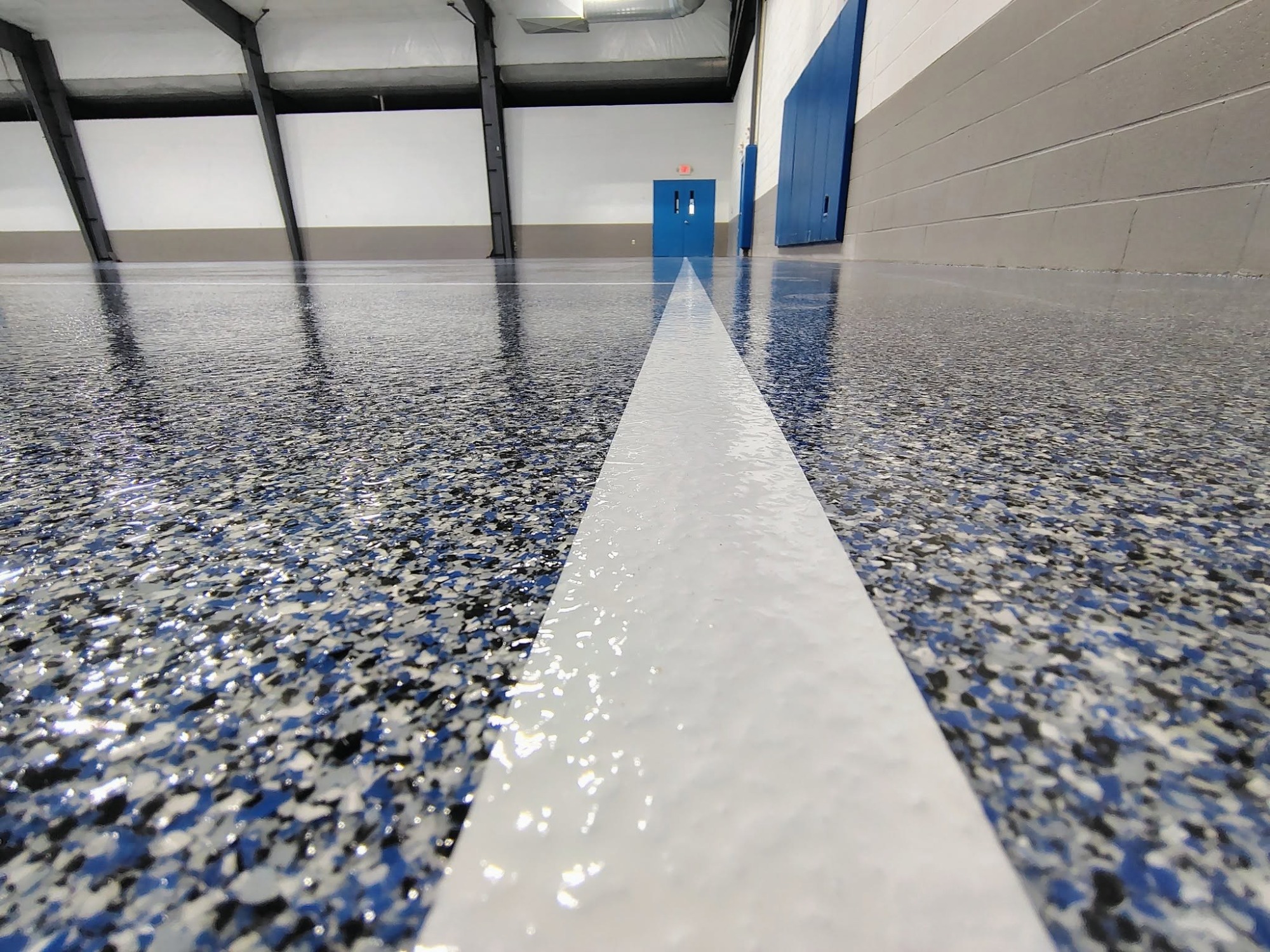 Blue and gray flake epoxy floor with a white line stripe.